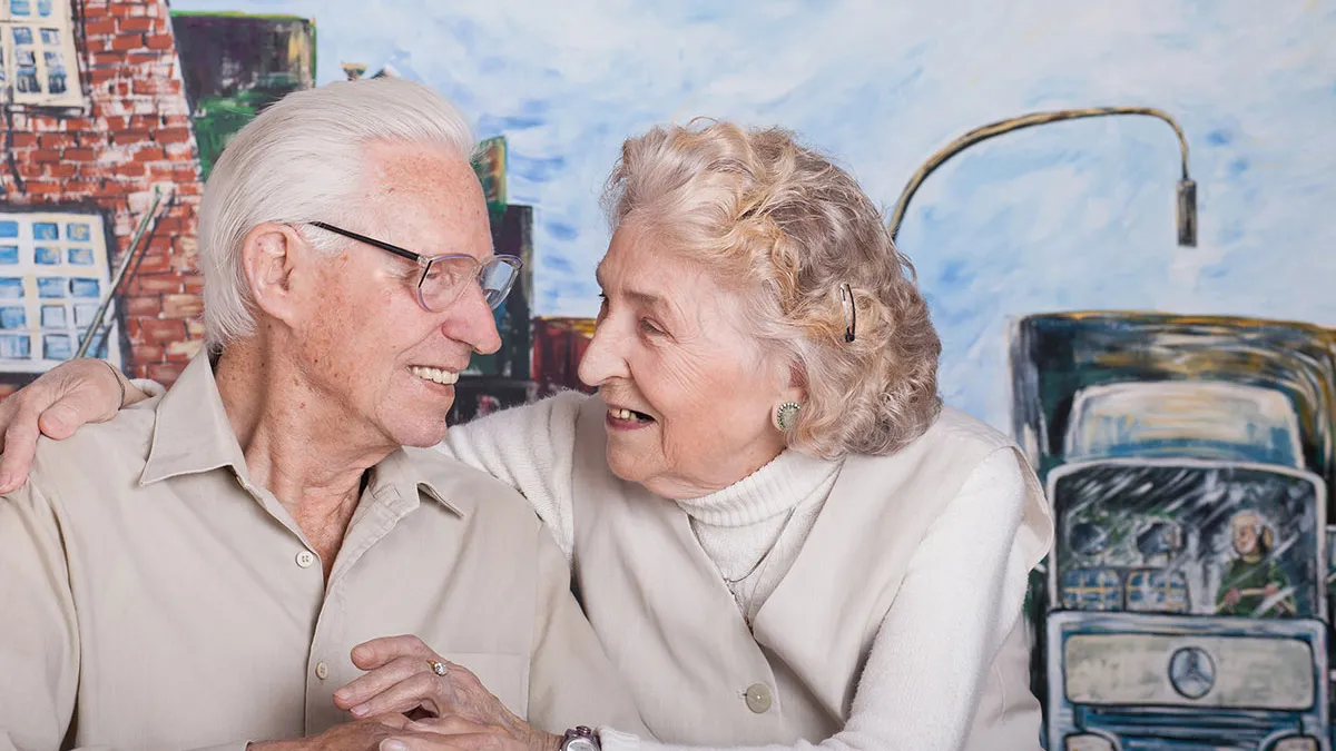 Ehepaar, das im PFLEGEN & WOHNEN HAMBURG in Altona lebt, lächelt sich an.