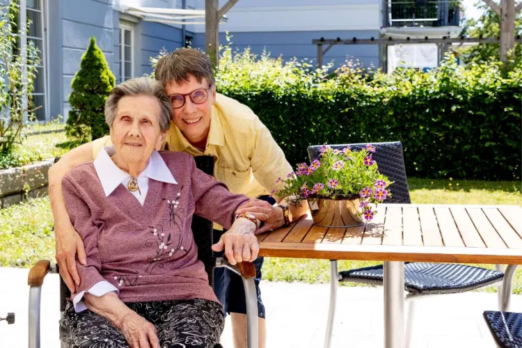 Elvira Gauert und ihre Angehörige im Außenbereich des Standorts Holstenhof bei PFLEGEN & WOHNEN HAMBURG.