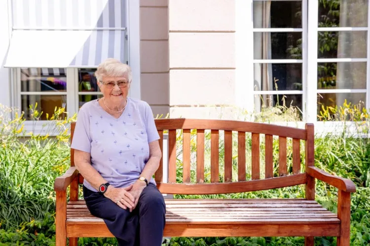 Margarete Halberstadt, Bewohnerin bei PFLEGEN & WOHNEN HAMBURG auf einer Bank im Außenbereich am Standort Finkenau.
