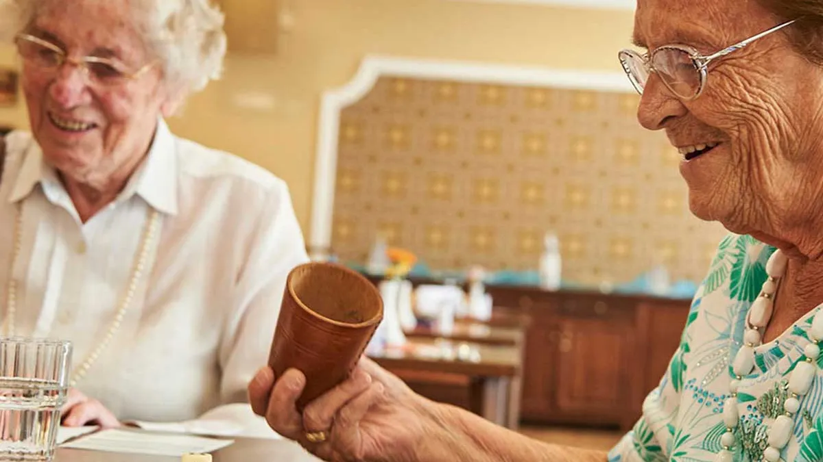 Bewohnerinnen von PFLEGEN & WOHNEN HAMBURG Alsterberg spielen gemeinsam ein Würfelspiel.