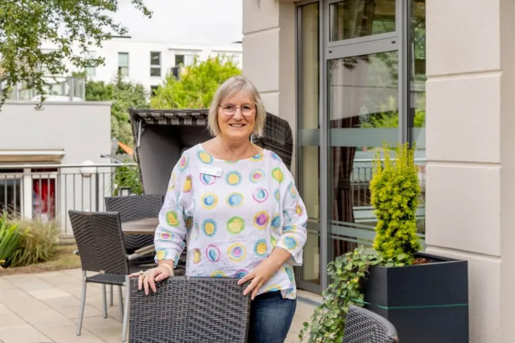 Ilona Wedhorn, Mitarbeiterin bei PFLEGEN & WOHNEN HAMBURG auf der Terrasse des Standorts Heimfeld, schätzt das vielfältige Team und die Zusammenarbeit.