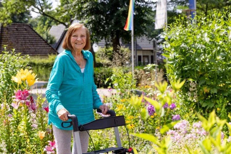 Helga Pratz, Bewohnerin bei PFLEGEN & WOHNEN HAMBURG, vor einem schönen Außenbereich am Standort Alsterberg.